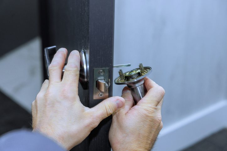 Mechanic installs lock handles on room doors